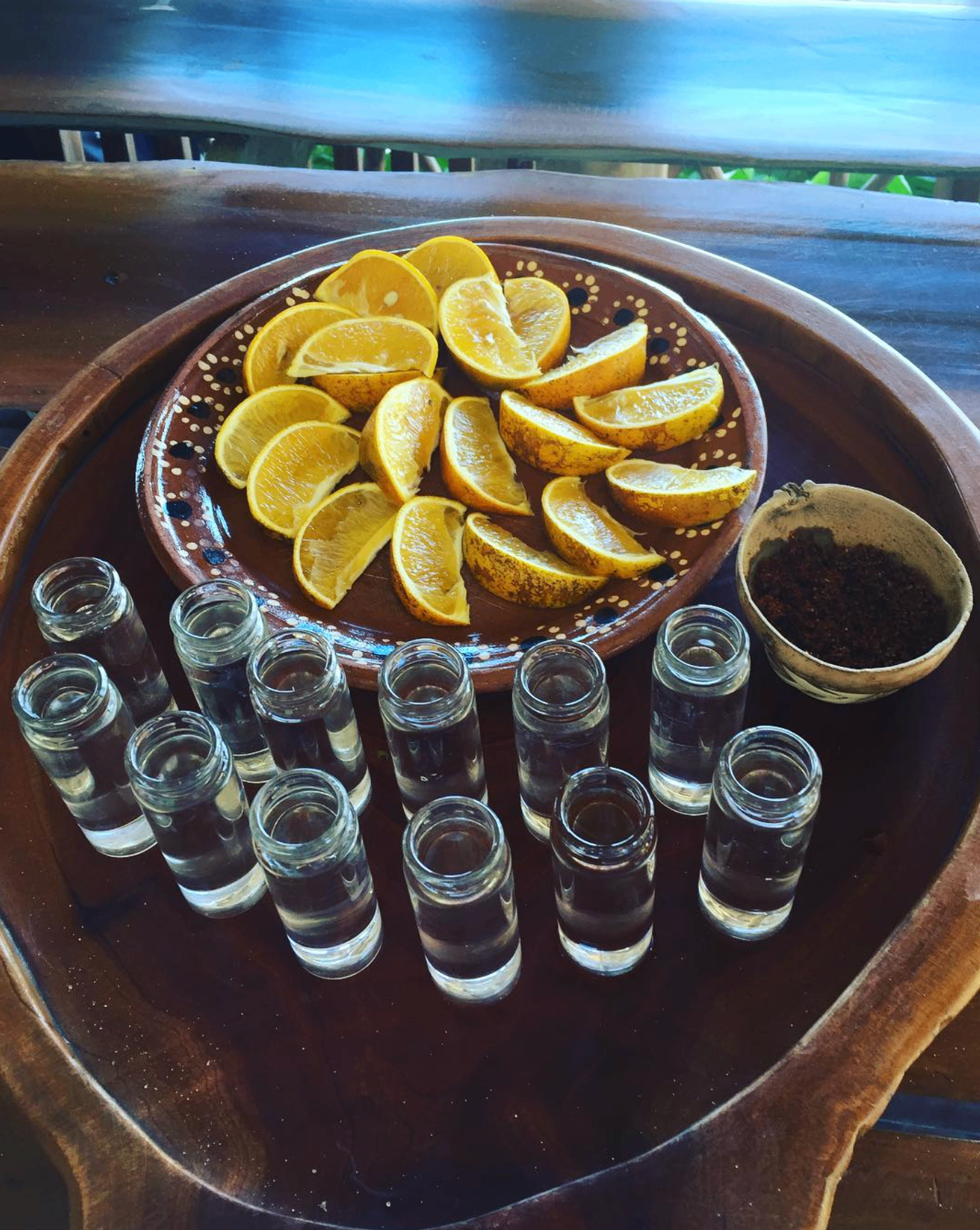 Tray of tequila tasting glasses with orange wedges and chili salt