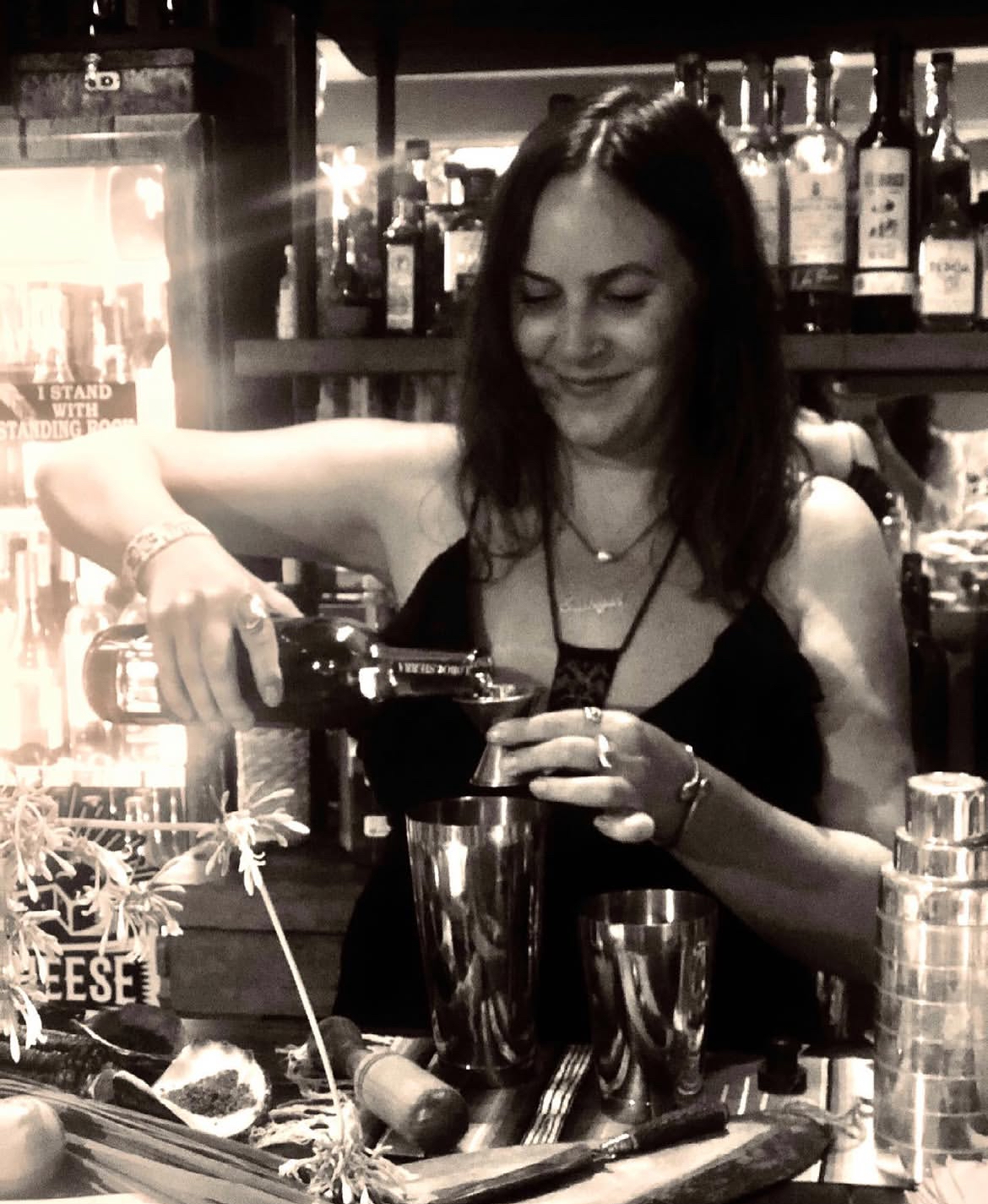 Sabi pouring a cocktail into a shaker